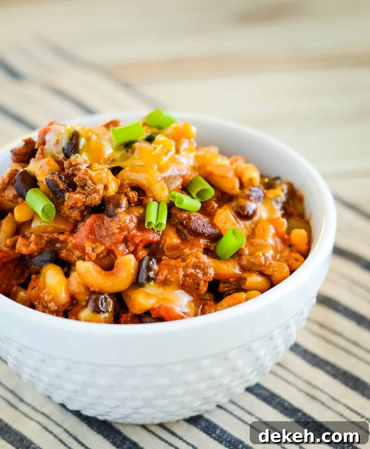 bowl of chili mac and cheese garnished with green onions