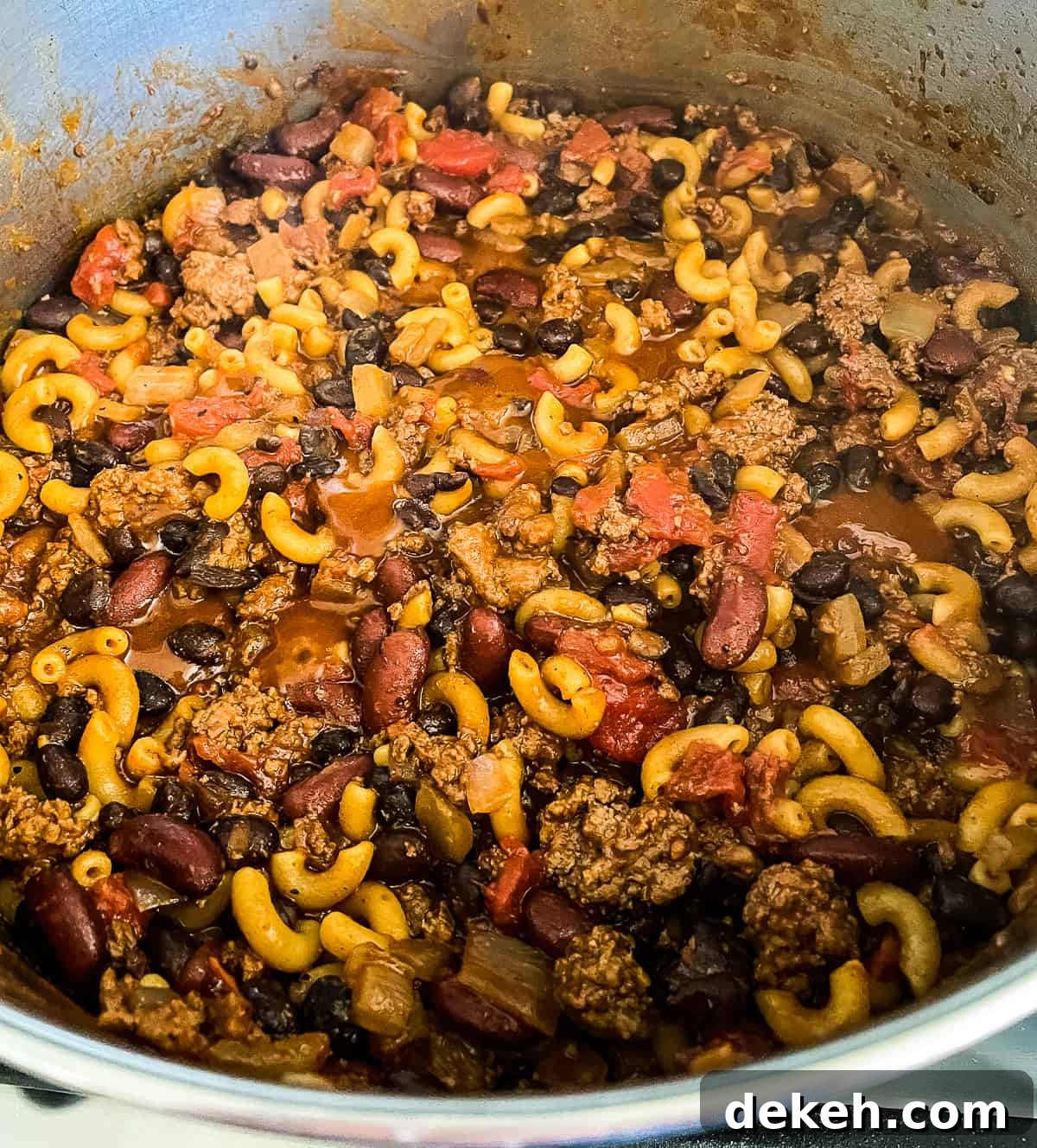 cooked pot of ground beef, macaroni, spices, and diced tomatoes