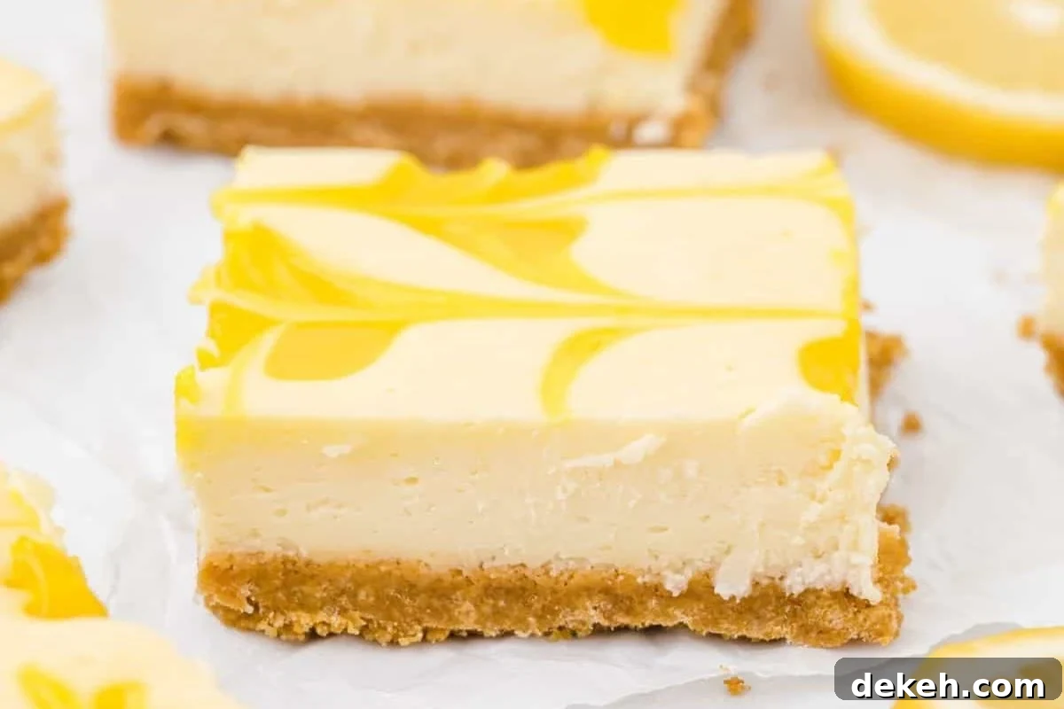 Delicious lemon cheesecake bars with a creamy filling and a graham cracker crust, topped with vibrant lemon swirls.