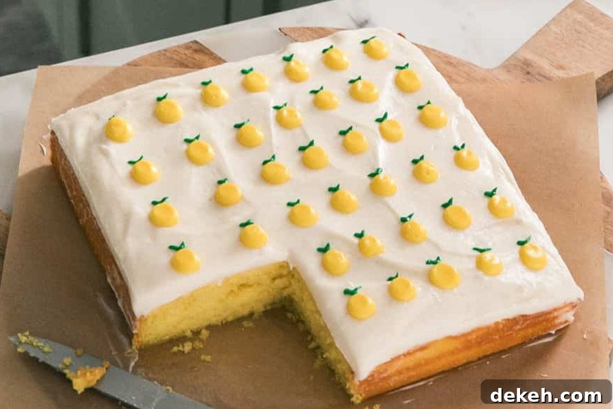 A yellow frosted cake decorated with tiny lemon-shaped toppings and a slice cut out, resting on a wooden surface.