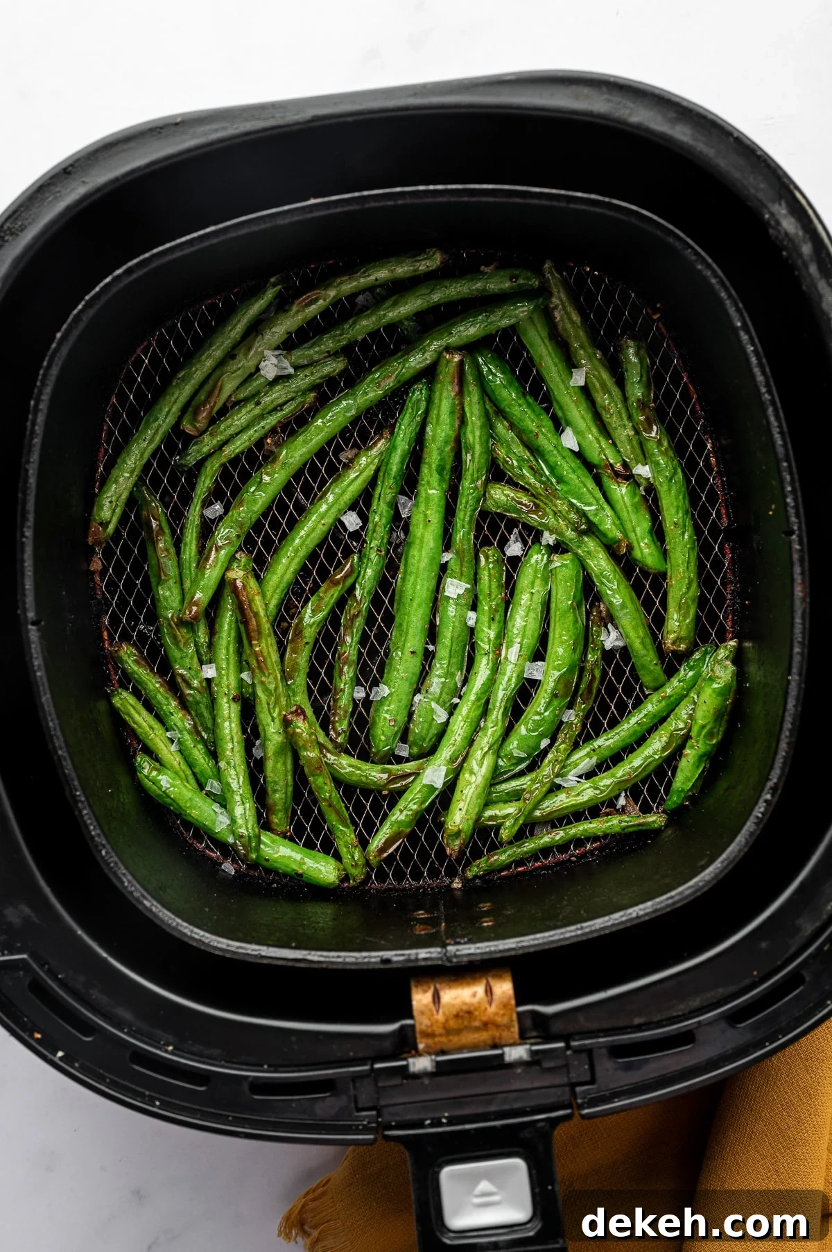 Air fryer green beans freshly cooked with light blistering and crisp edges.