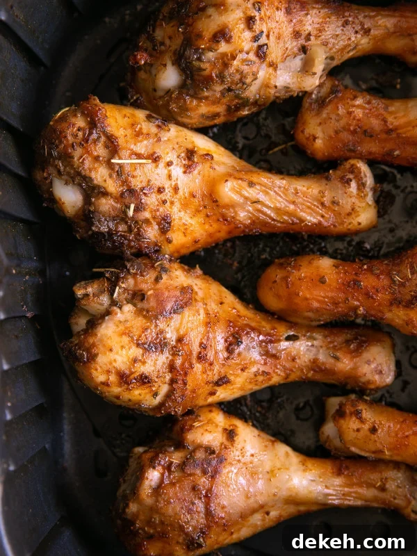 Fully cooked and well seasoned air fryer chicken legs still in the air fryer basket.