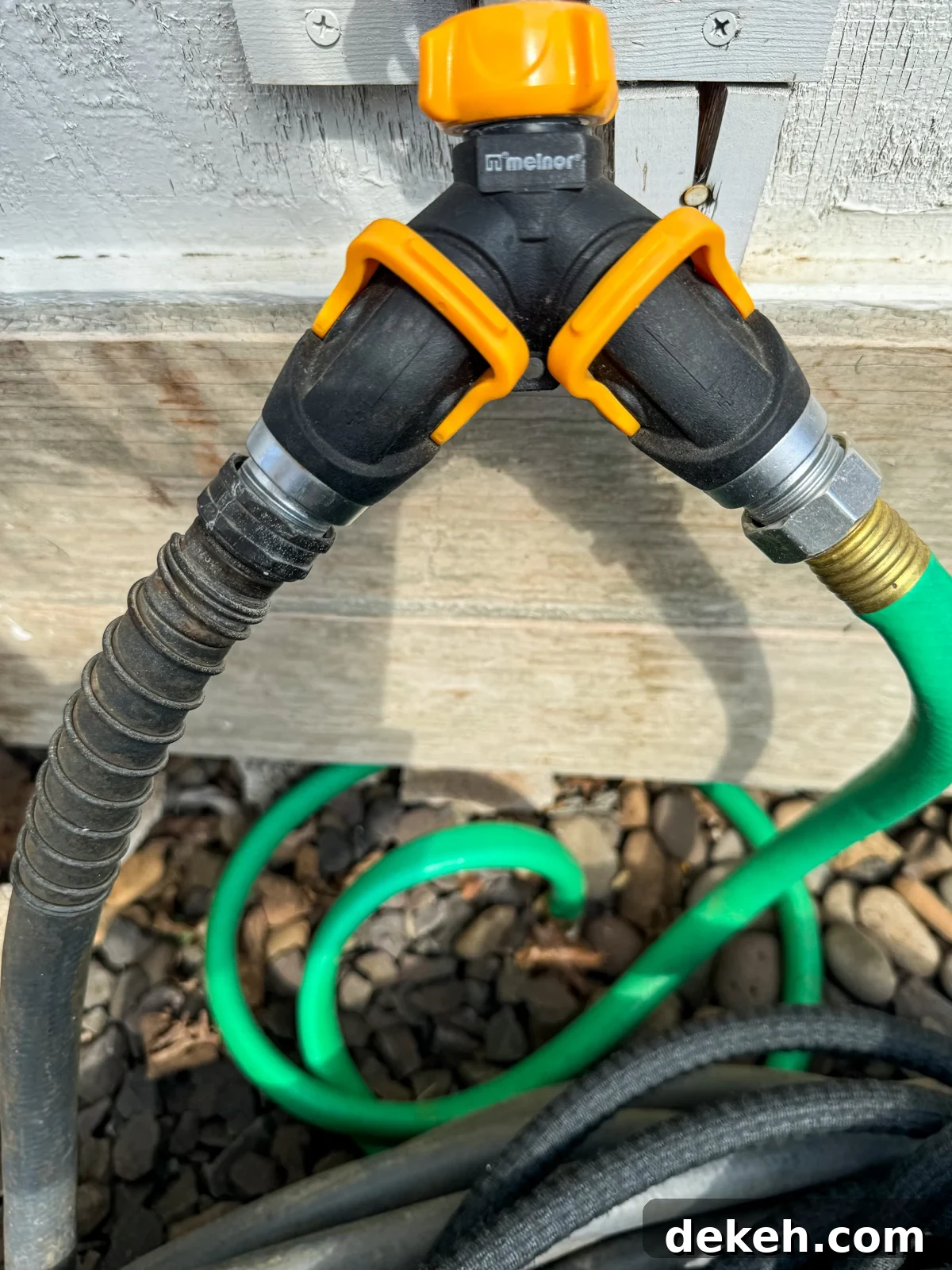 2-Way hose valve with orange levers in the garden