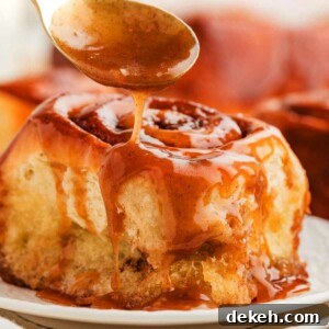 Drizzling caramel sauce over a sticky cinnamon roll.