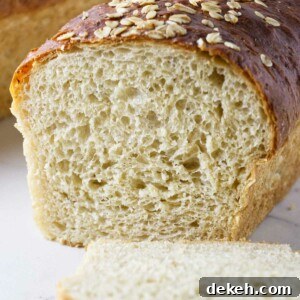 A loaf of oatmeal bread sliced in half to show the interior crumb.