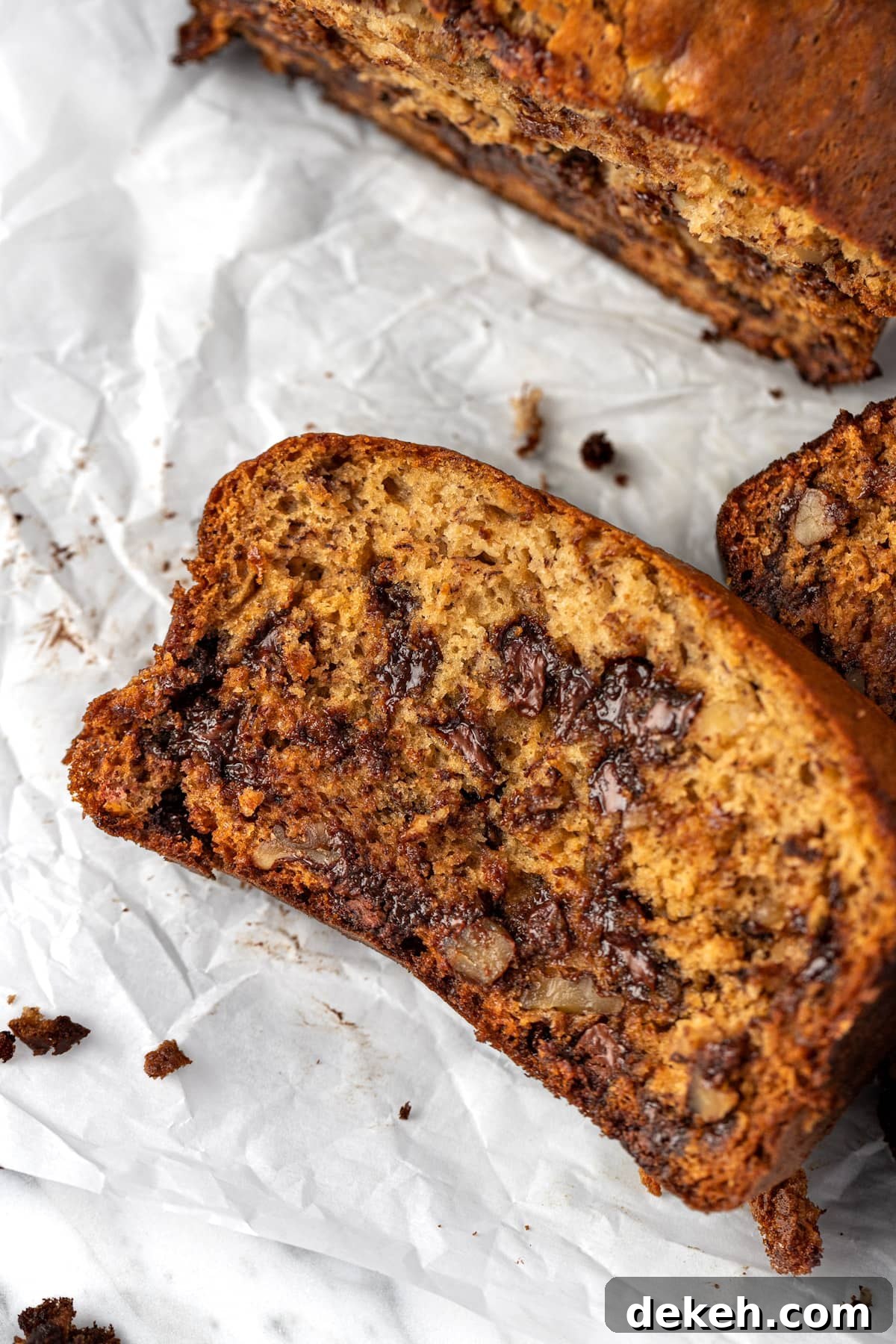Overhead view of a slice of banana ricotta bread on a piece of crumpled parchment paper.