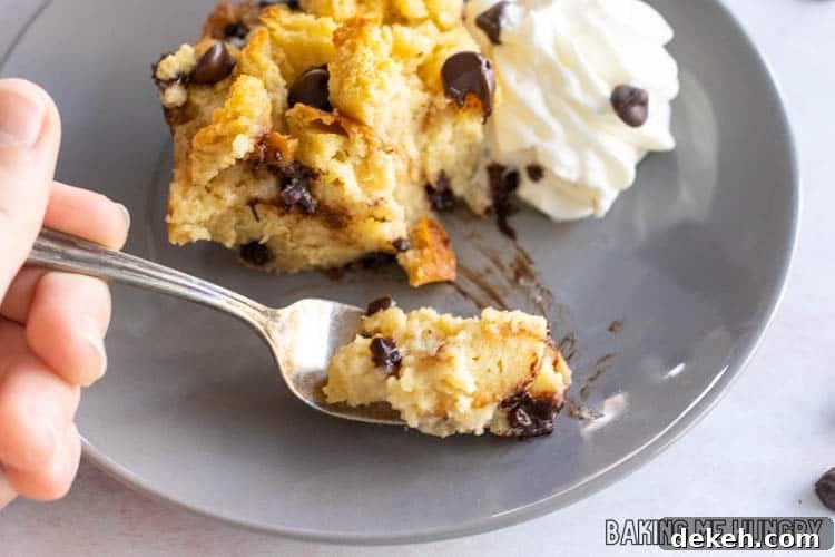 fork holding up a bite of chocolate chip bread pudding