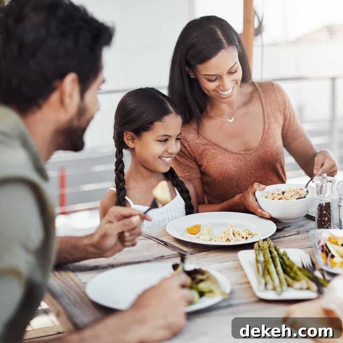 Parents and daughter eating a meal at kitchen table