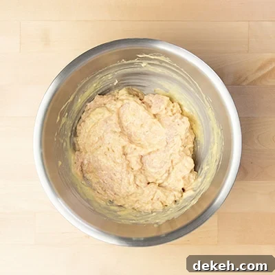 round chicken mixed with yellow mixture in mixing bowl