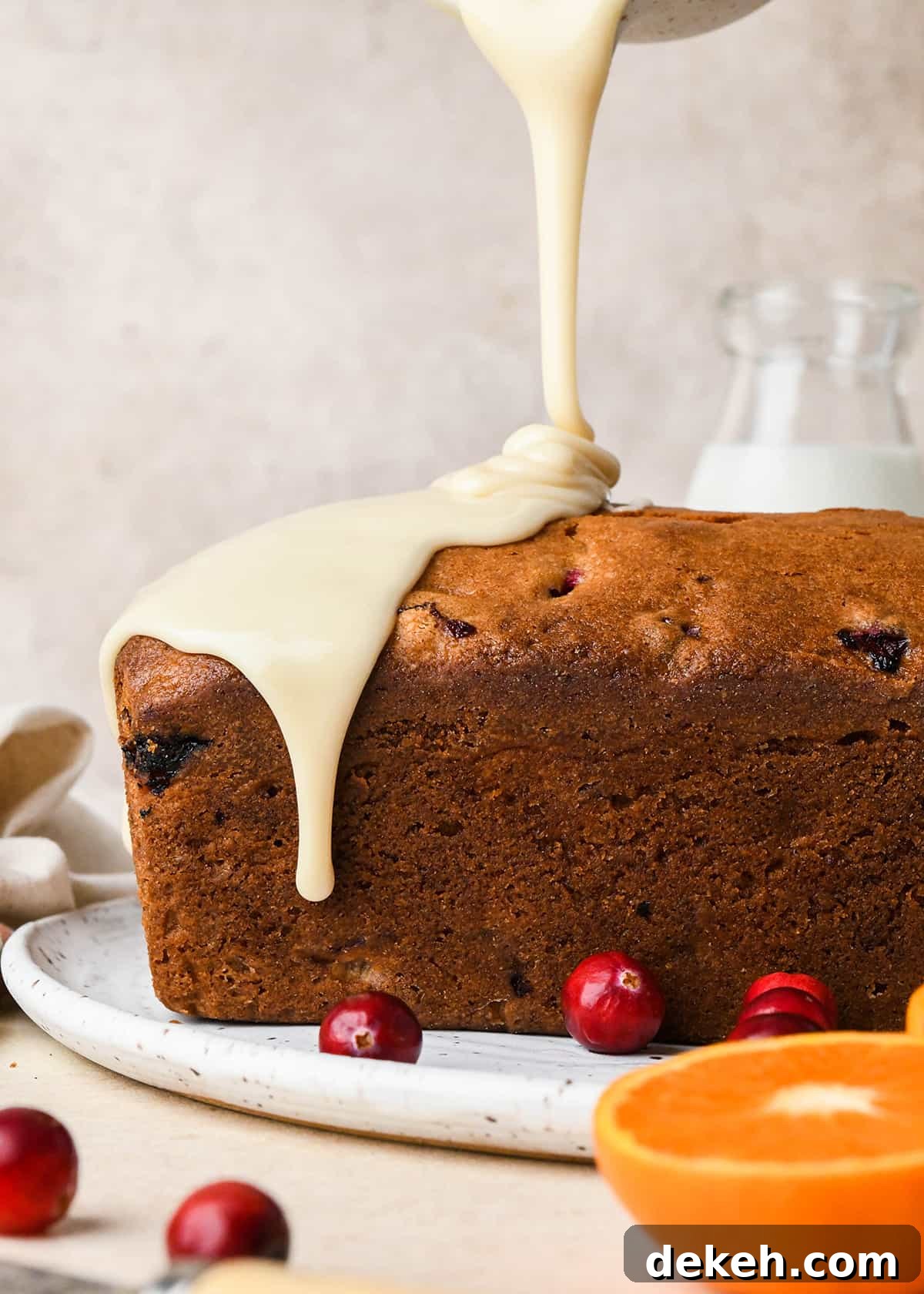 glaze being poured onto Cranberry Orange Bread