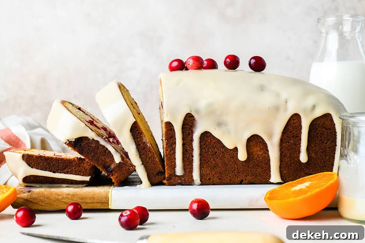 a loaf of Cranberry Orange Bread with 3 slices cut out of it