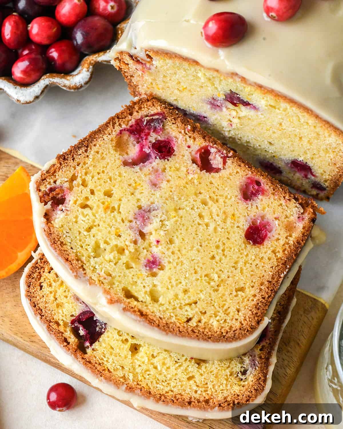 a loaf of Cranberry Orange Bread with 2 slices cut out of it