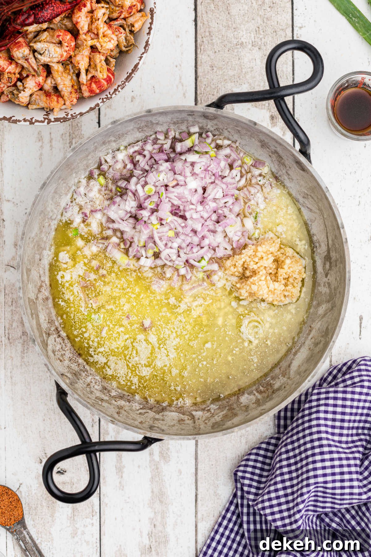 A skillet with melted butter and onions.