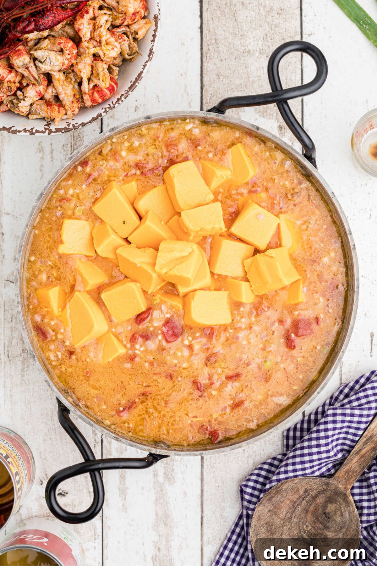 Cubes of velveeta added to a skillet making a cheese sauce.