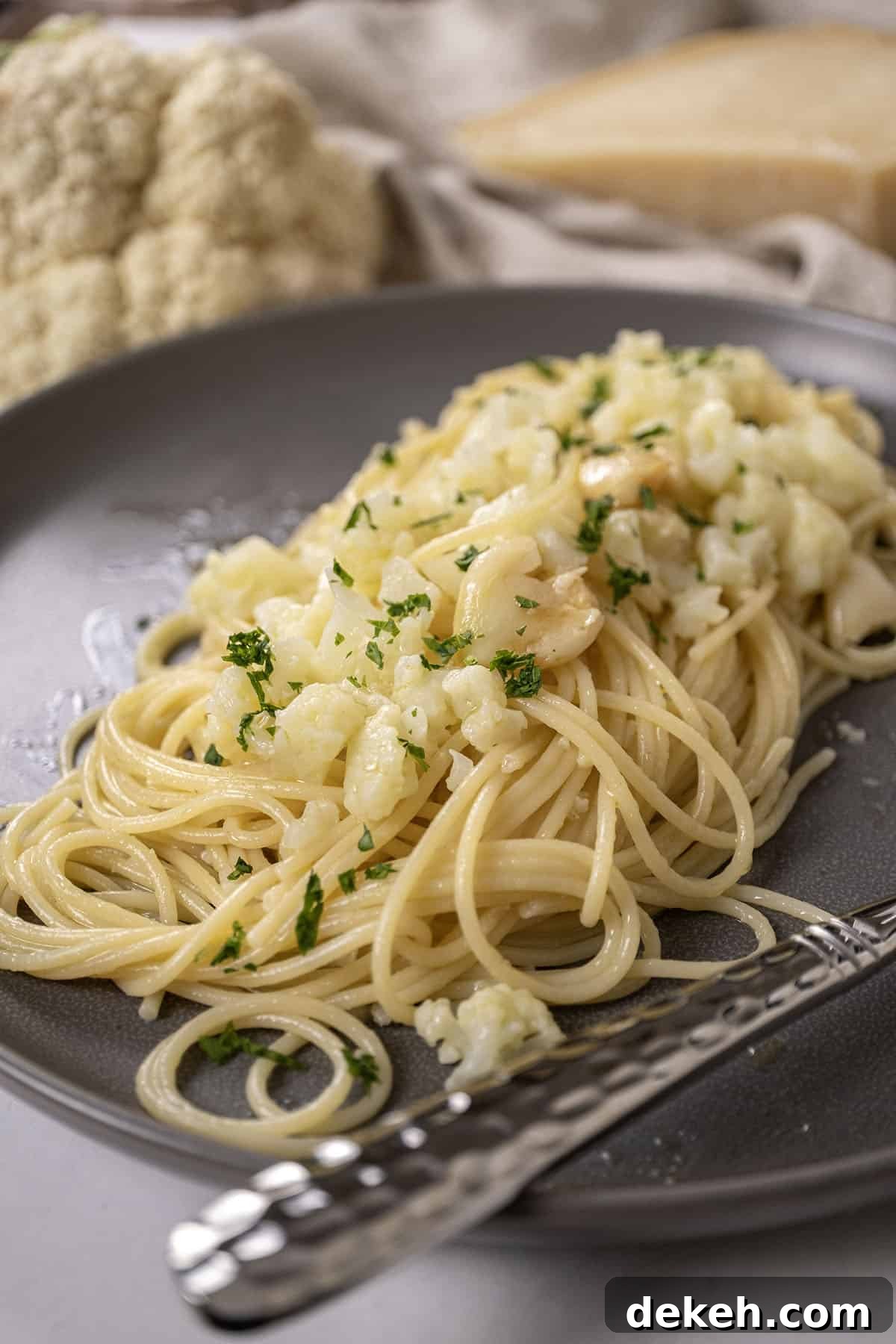 spaghetti with cauliflower plated on a dish garnished with parsley.