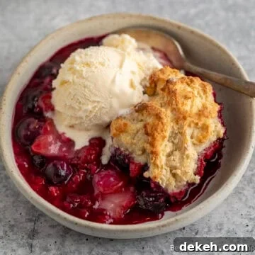 Triple Berry Cobbler topped with a scoop of ice cream.