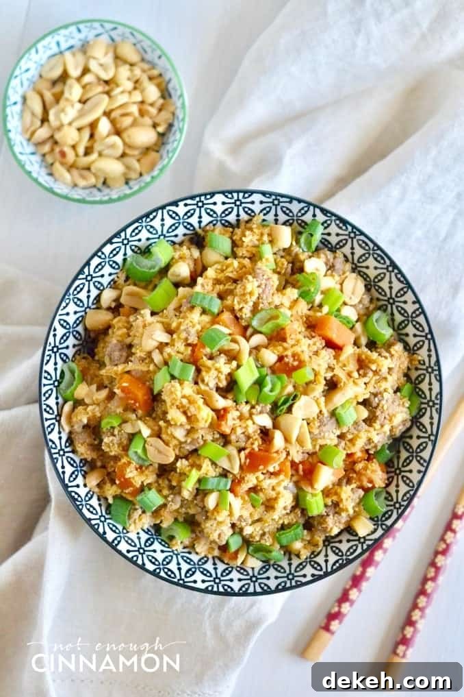 overhead shot of a bowl of healthy Asian cauliflower fried rice with some peanuts on the side