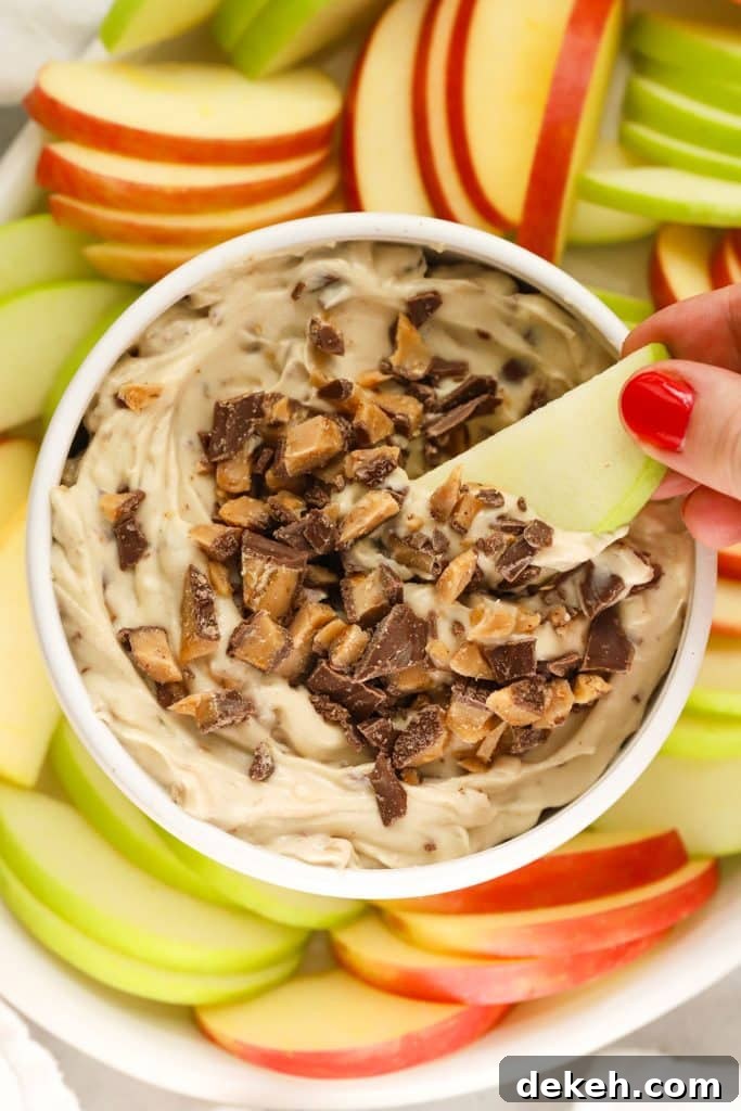 dipping apple slice into toffee fruit dip