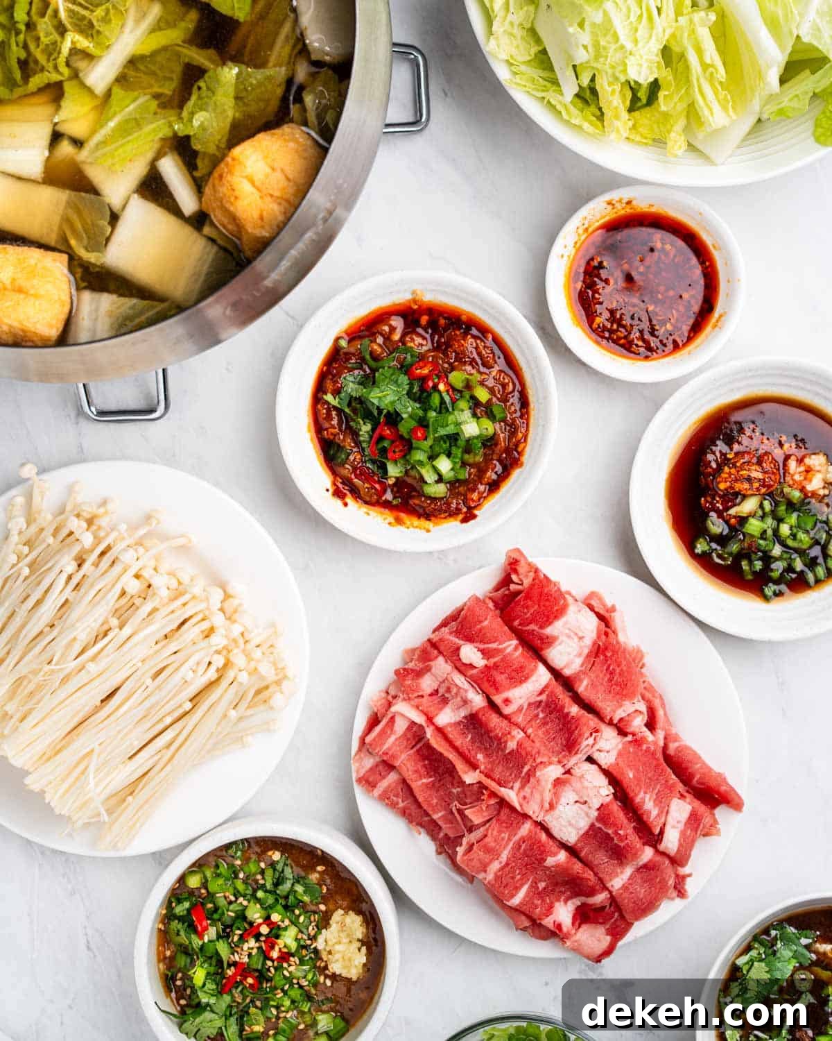 hot pot ingredients and dipping sauces laid out on table.