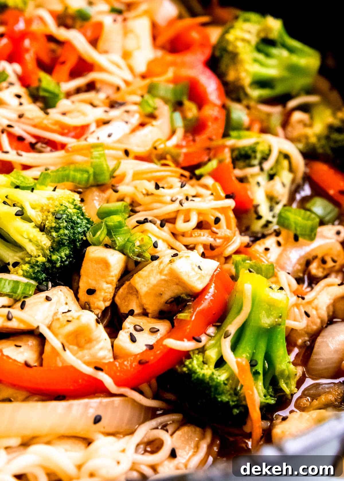 juicy chicken, tender shirataki noodles, red bell peppers, broccoli florets covered in stir fry sauce in a skillet