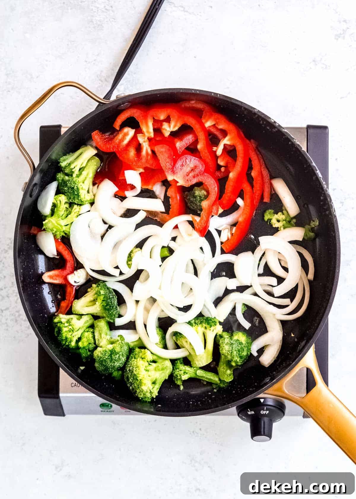 frozen broccoli, sliced onion, and sliced red pepper in a skillet