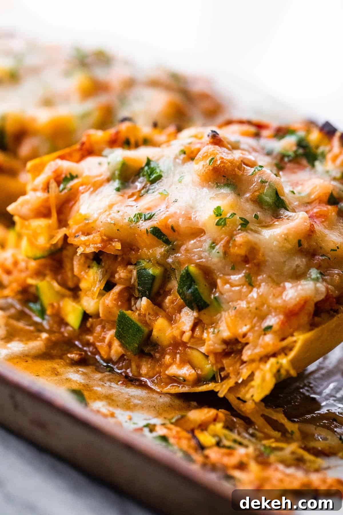 halved spaghetti squash stuffed with chicken enchilada filling and topped with melted cheese