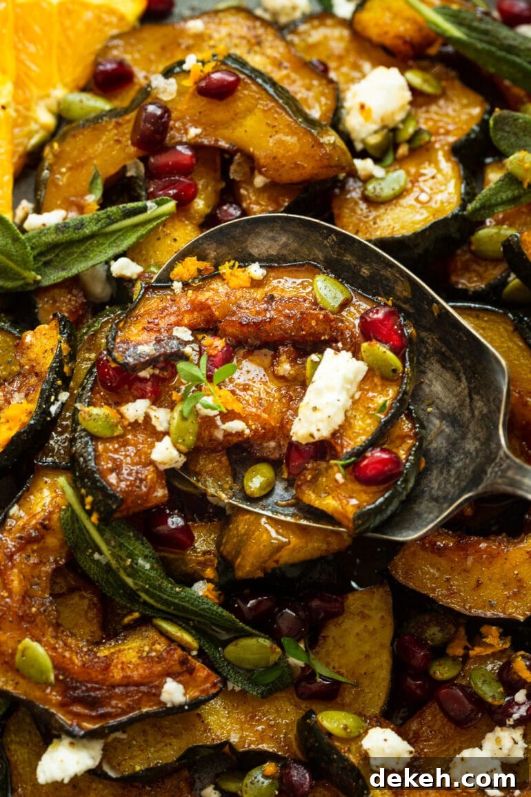 a photo of a large serving spoon dishing up a roasted holiday acorn squash