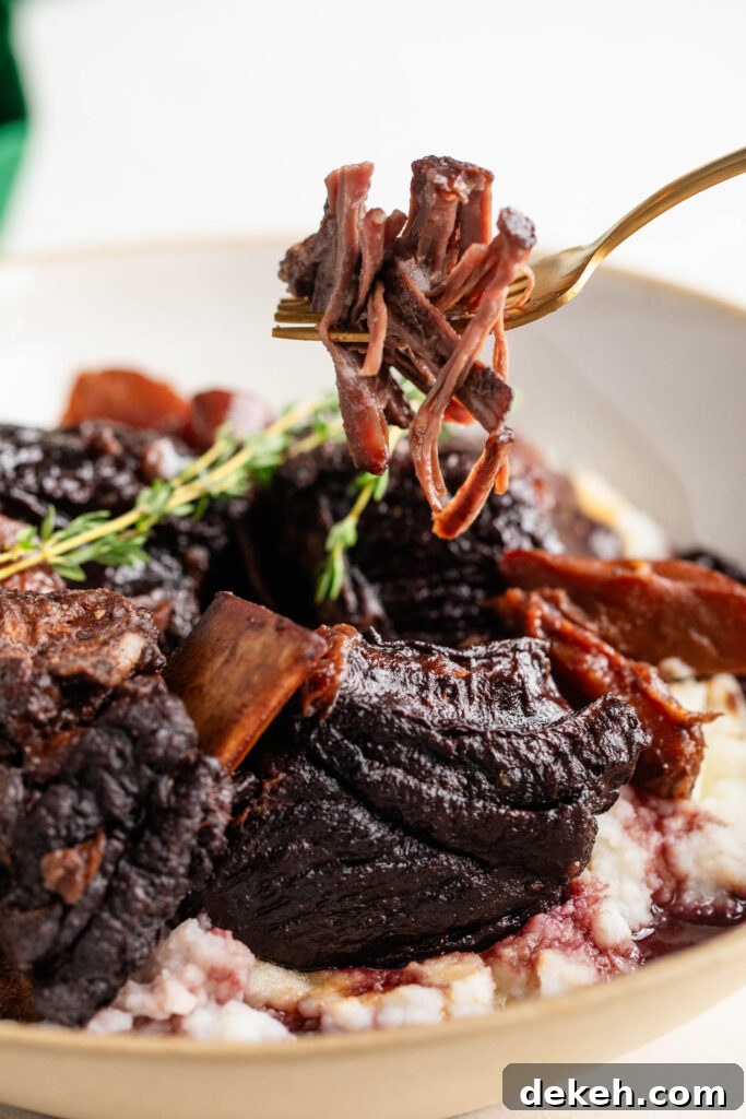 bowl of braised beef short ribs with a fork full of meat