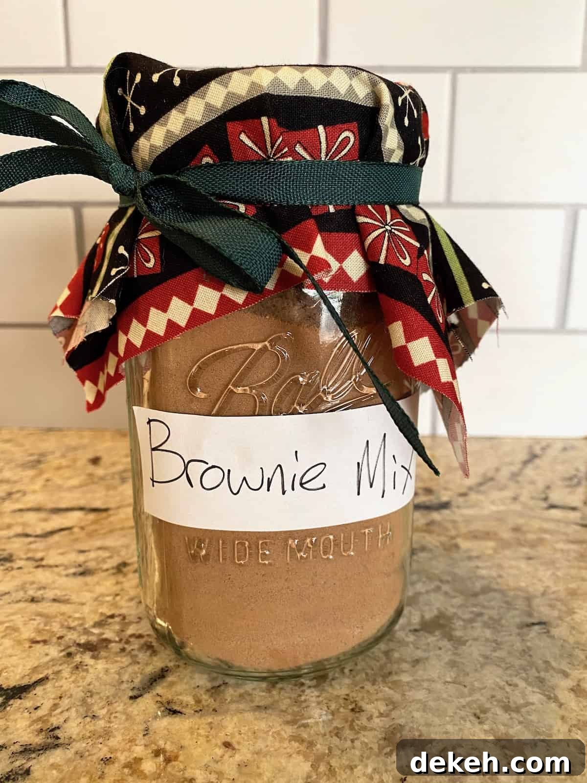 A jar of brownie mix with a ribbon and fabric on the top of the jar.