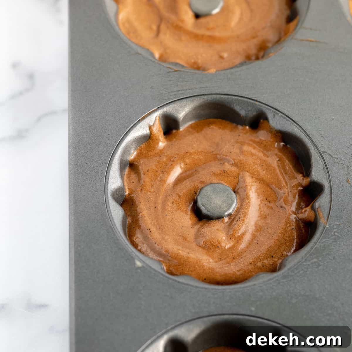 Chocolate cake batter in a mini bundt pan.