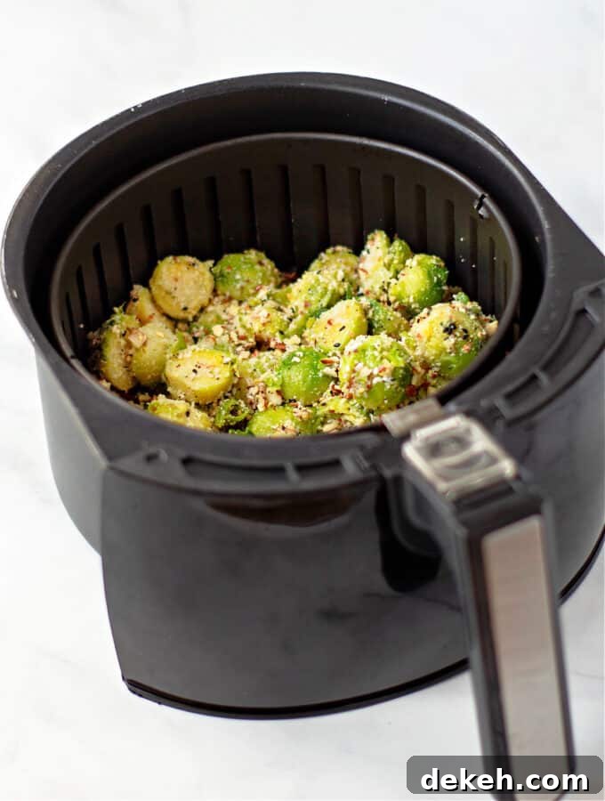frozen seasoned brussel sprouts in air fryer basket.
