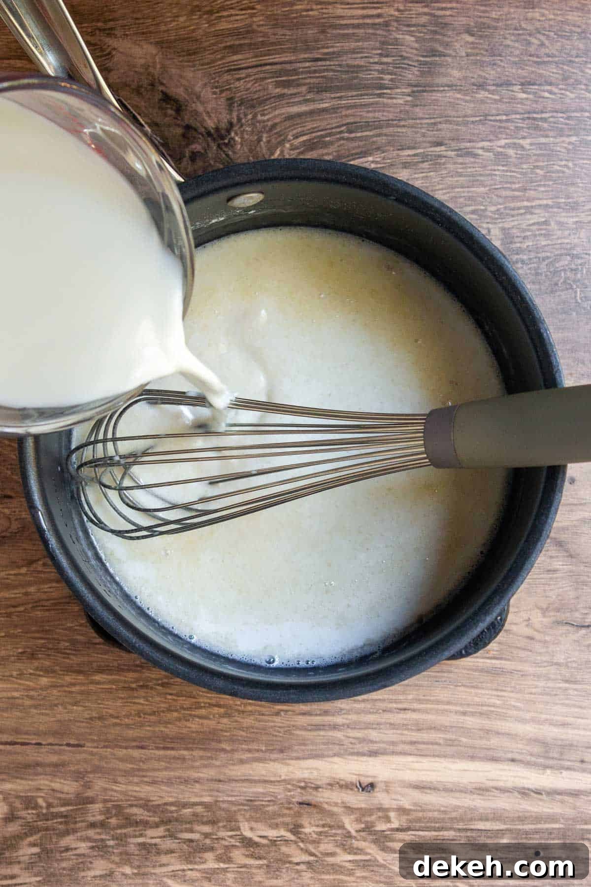 Southern Country Gravy Recipe for Biscuits and Breakfast Plates 6 Milk slowly pouring into flour-grease mixture.