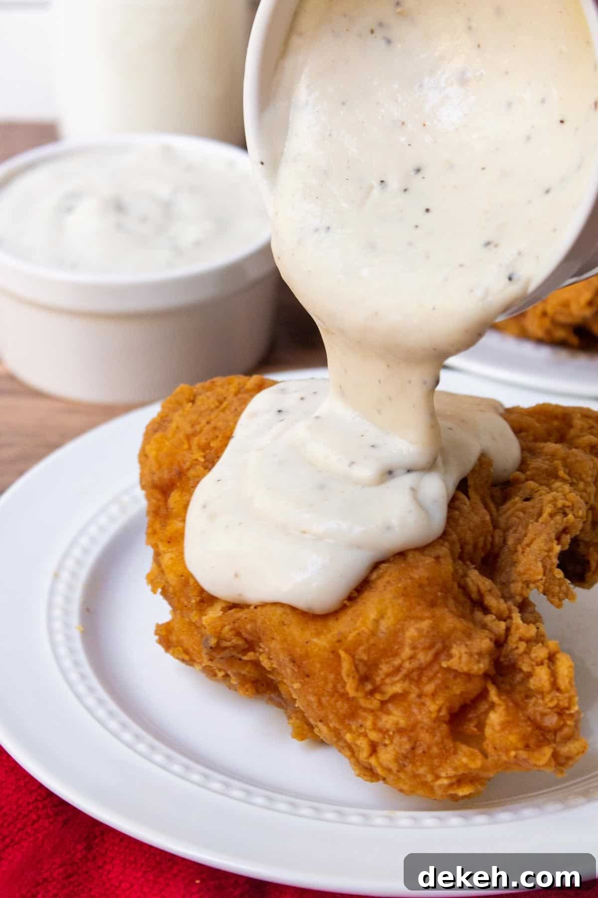 Southern Country Gravy Recipe for Biscuits and Breakfast Plates 9 Pouring southern white gravy over fried chicken