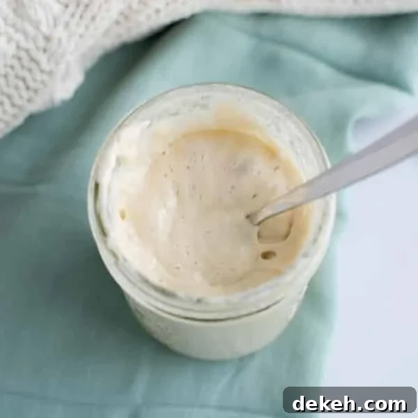 Replace Commercial Yeast with a Sourdough Starter 8 Jar of active sourdough starter with a spoon showing a smooth, bubbly texture.