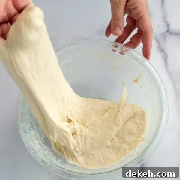 Replace Commercial Yeast with a Sourdough Starter 9 Sourdough dough being stretched in a bowl.