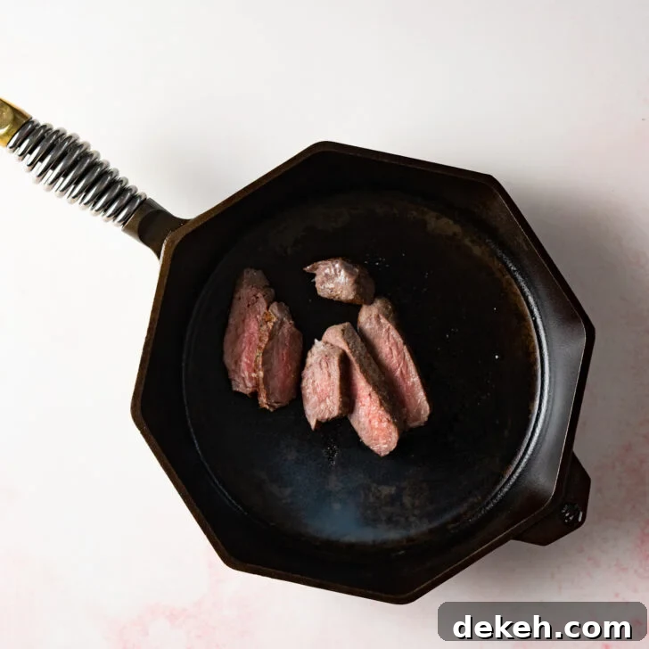 How to Reheat Steak: Stovetop, Oven & Sous Vide Methods 2 Sliced steak in cast iron skillet
