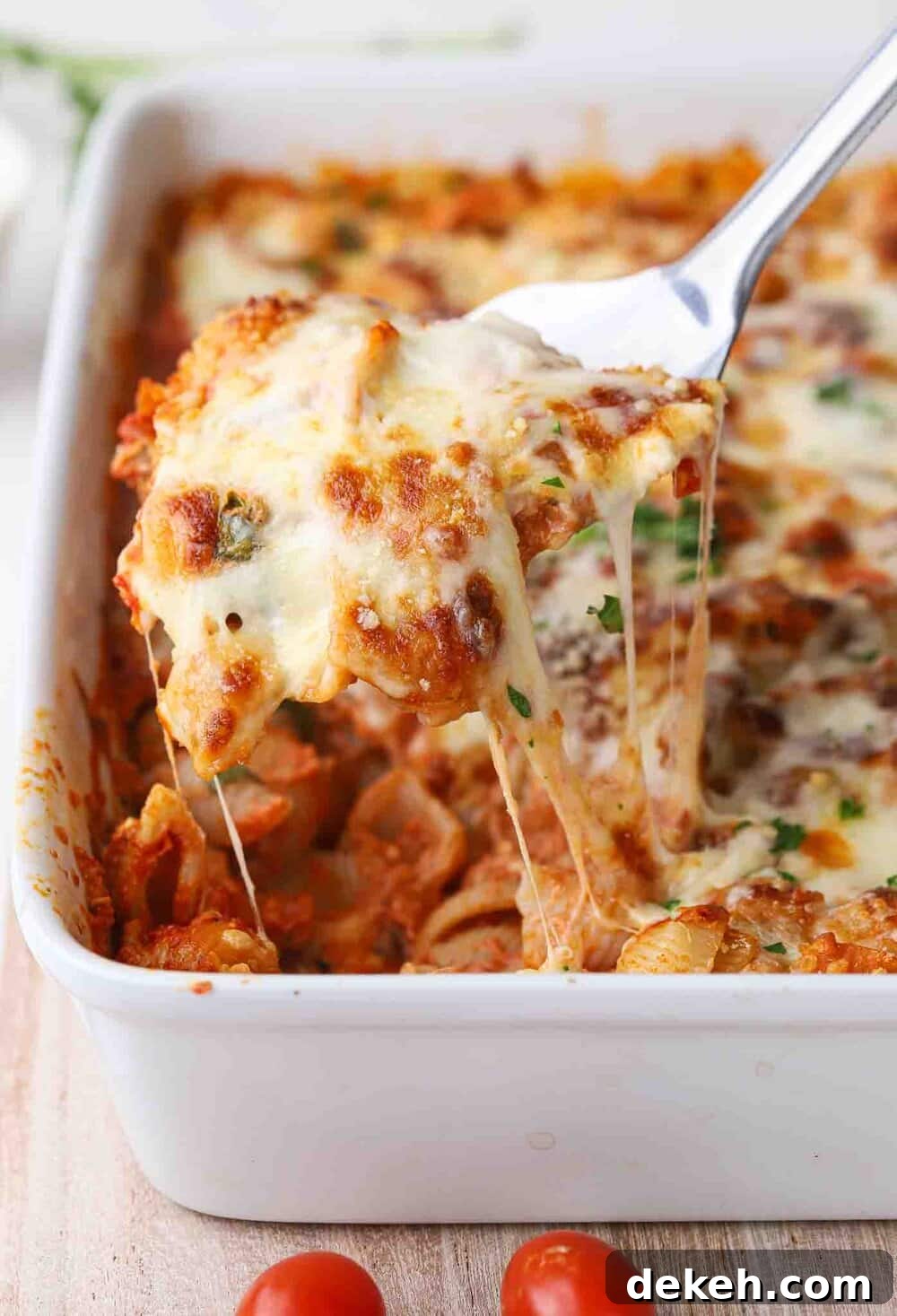 Cheese pull shot with a baked pasta dish.
