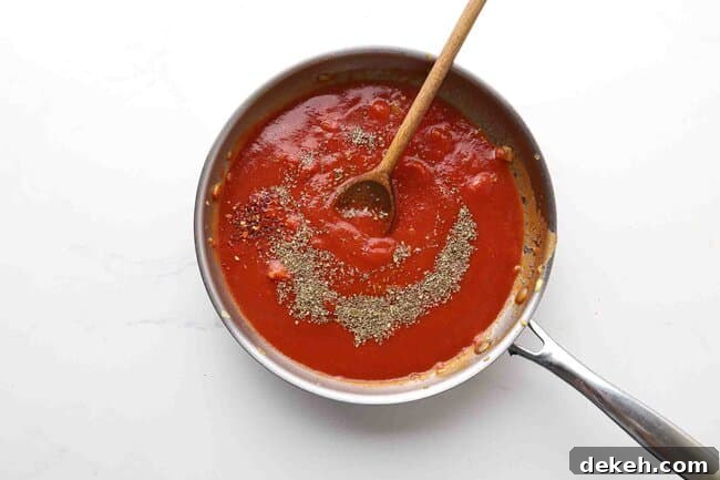 Tomato sauce and spices in pan.