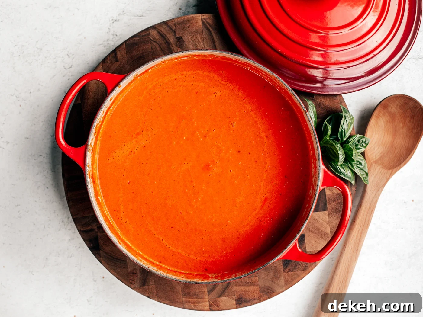 Creamy Homemade Tomato Soup Recipe with Basil and Garlic 6 Big pot of tomato soup on a wooden cutting board.