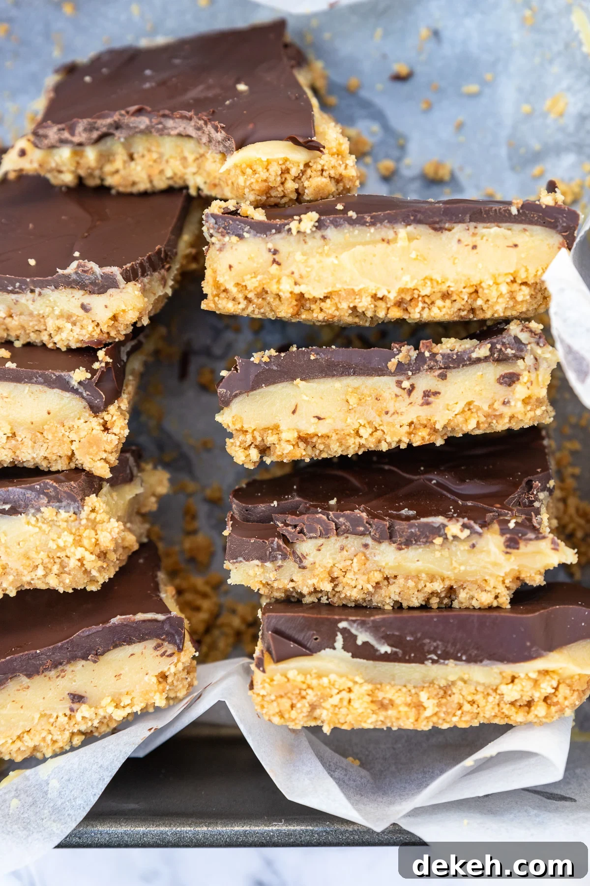 No-Bake Peanut Butter Crunch Bars — 6 Ingredients 8 Closeup of slices of no-bake caramel slice on their sides in a baking tin