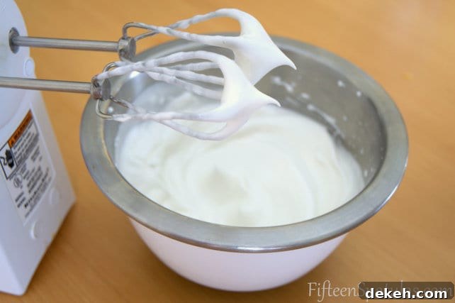 Stiff Egg Whites for Crispy Waffles | FifteenSpatulas.com Stiff Peak Egg Whites Shown on Beater with Bowl