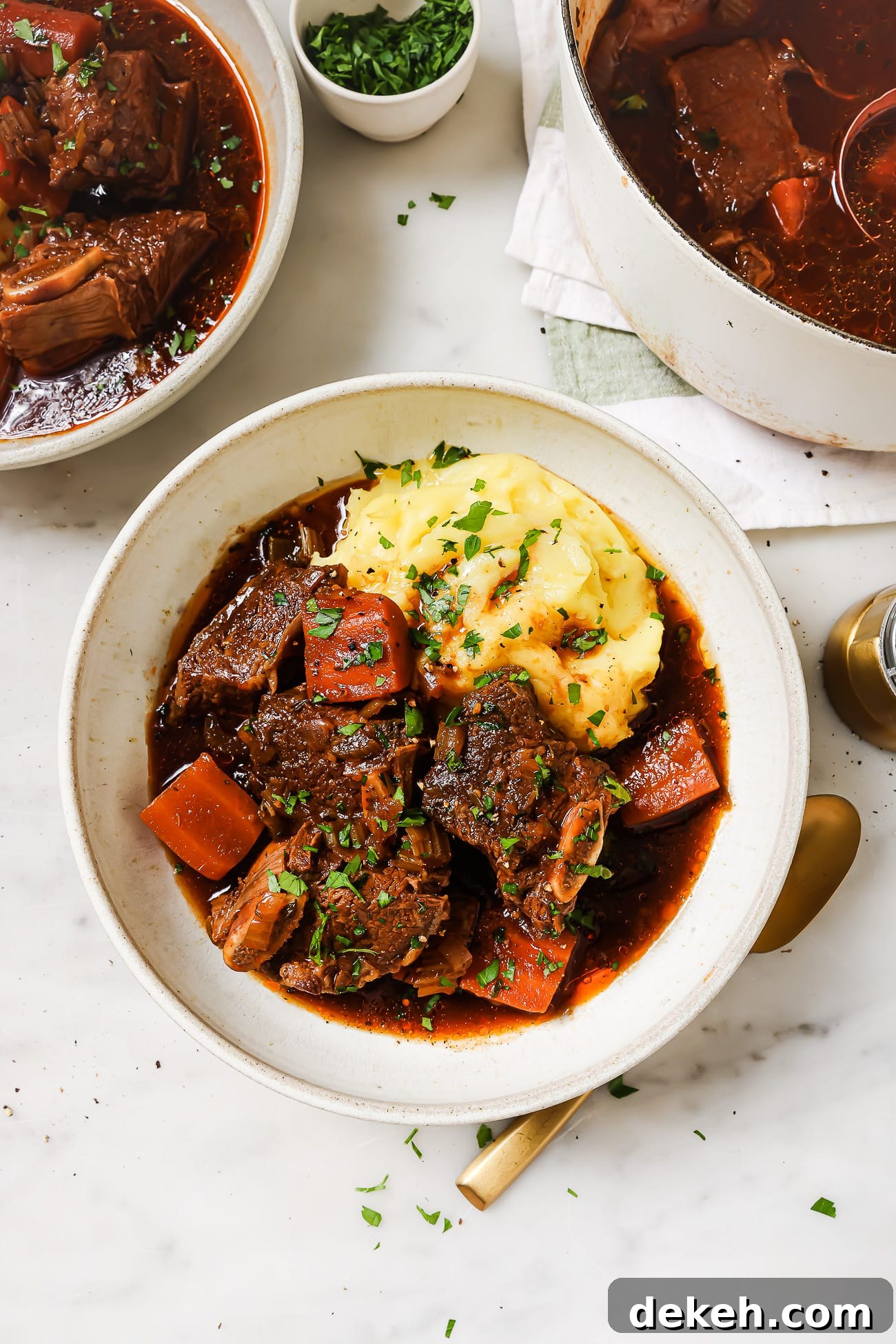 Tender Guinness-Braised Short Ribs 7 Guinness braised short ribs over mashed potatoes in a white bowl.