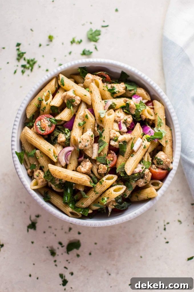 Balsamic Caprese Pasta Salad with Mozzarella and Tomatoes 2 balsamic Caprese pasta salad in a white bowl beside cloth napkin