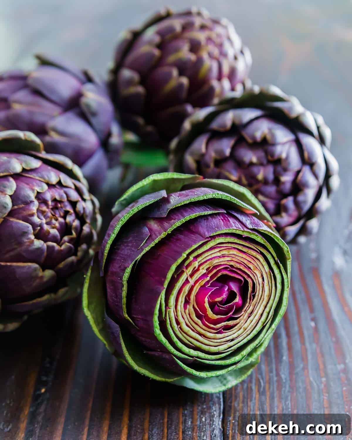 Purple artichokes on a wooden table.
