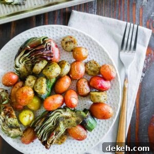 Roasted vegetables and potatoes on a plate with a fork.