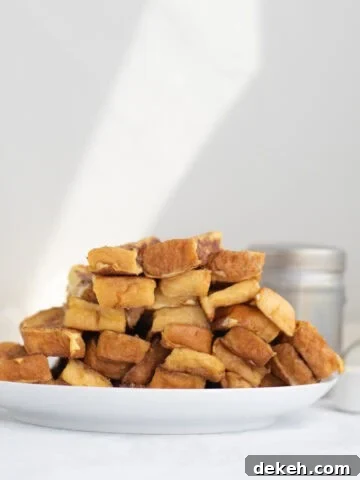 a pile of french toast sticks on a white plate