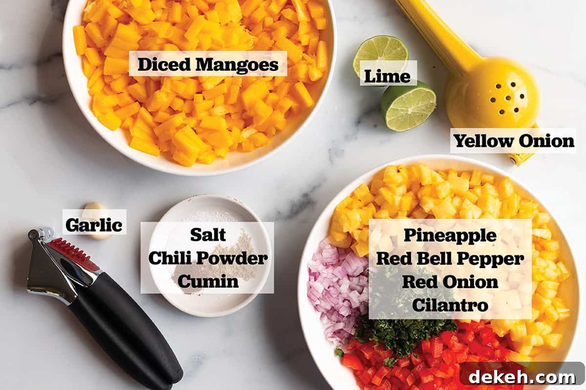 Zesty Mango and Pineapple Salsa with Lime and Cilantro 3 A bowl of diced mangos, galore, salt, chili powder, cumin, lime and another bowl of pineapple, red onion and red peppers.