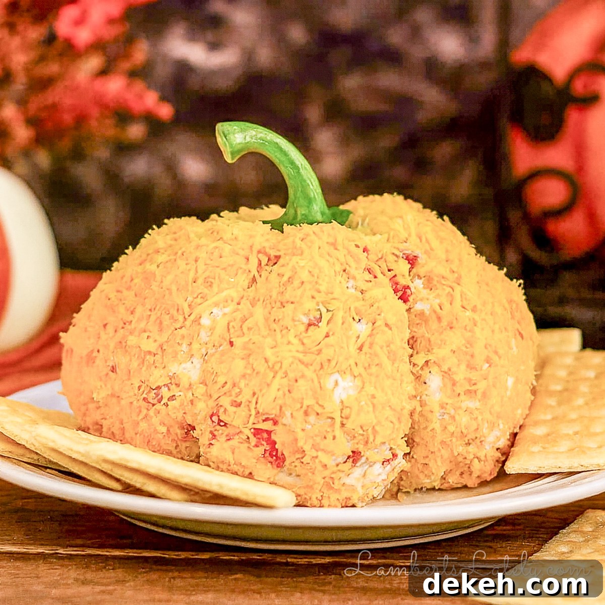 pumpkin cheese ball on a plate surrounded by crackers.