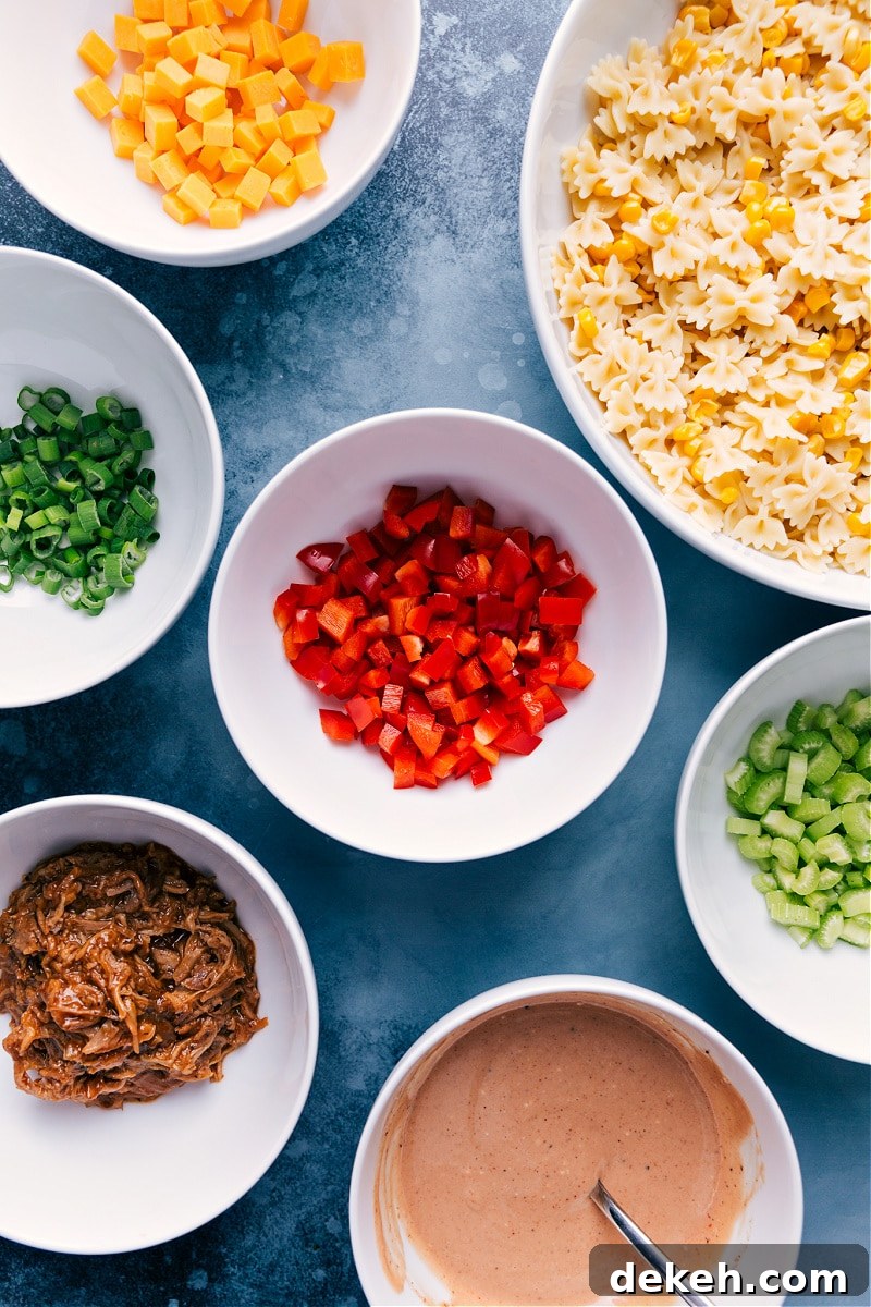 Ingredients In BBQ Pasta Salad Prepped Out Ingredients prepped out for this recipe prepped out for easy assembly including the cheese, pasta, peppers, green onions, celery, pork, and sauce.